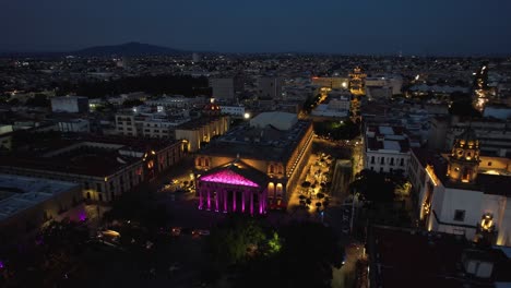 Aerial-view-around-the-illuminated-Teatro-Degollado,-night-in-Guadalajara,-Mexico---orbit,-drone-shot
