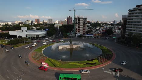 Aerial-view-around-the-Minerva-statue-and-traffic-circle,-Guadalajara,-Mexico---low,-circling,-drone-shot