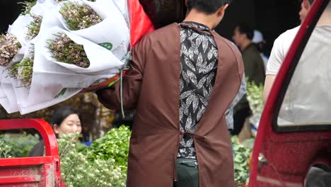 Kunming,-Yunnan,-China---September-1,-2022:-a-man-moving-flowers-at-the-Kunming-Dounan-Flower-Market