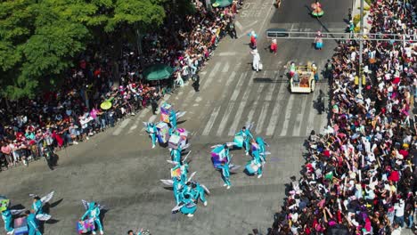 People-in-costumes-throwing-a-person-in-the-air-at-the-Dia-de-Muertos-parade,-in-Mexico-city---aerial-view