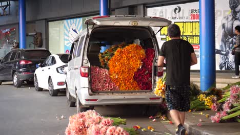 Kunming,-Yunnan,-China---September-1,-2022:-a-man-loading-flowers-into-the-car-at-the-Kunming-Dounan-Flower-Market