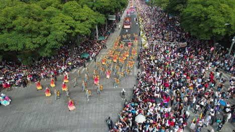 Aerial-view-of-people-in-colorful-costumes-marching-at-the-Day-of-the-dead-parade-on-Reforma-avenue,-in-Mexico-city