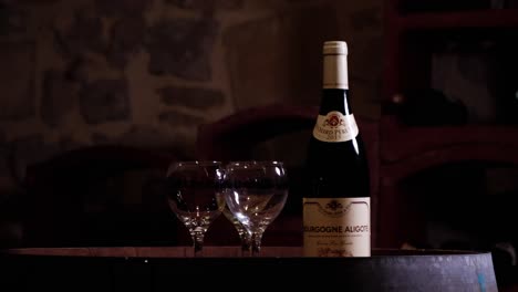 Revealing-shot-of-a-bottle-of-Bourgogne-Aligote-and-three-empty-glasses