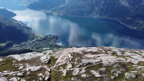 Popular-hiking-destination-Qeens-Trail-between-Lothus-and-Kinsarvik-in-Hardanger-Norway---Lots-of-people-walking-on-mountain-with-stunning-panoramic-view-over-Hardangerfjord-and-Lofthus-village