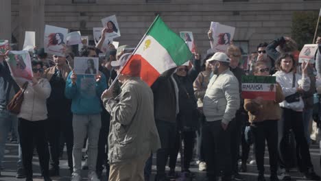 Hombre-Caminando-Con-La-Bandera-Del-Estado-Imperial-De-Irán-Protestando-Contra-El-Actual-Régimen-Opresivo-Iraní