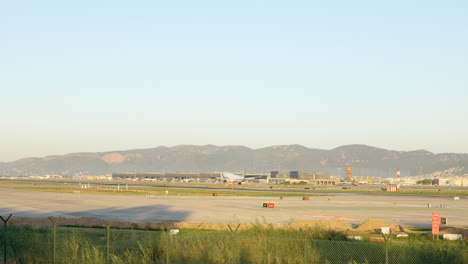 Tracking-shot-of-Vueling-airplane-landing-in-Barcelona-airport-runway,-day