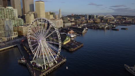 Aerial-view-aound-the-Seattle-Great-Wheel,-sunrise-in-WA,-USA---circling,-drone-shot