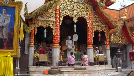 People-praying-at-typical-Thai-Buddhist-temple,-static-view