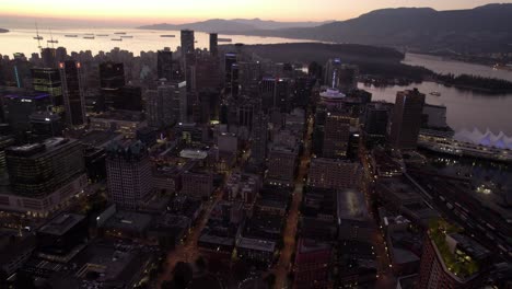 Aerial-view-overlooking-downtown-Vancouver,-dusk-in-BC,-Canada---tracking,-drone-shot