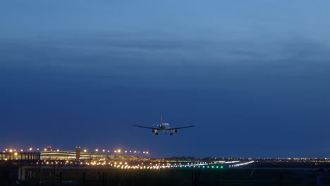 Start--Und-Landebahnlichter,-Die-Unter-Dem-Flugzeugrumpf-Beim-Aufsetzen-Am-Flughafen-Barcelona-Zur-Blauen-Stunde-Reflektieren