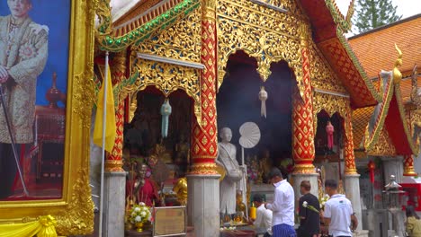 Reveal-tilt-down-over-Thai-Buddhist-temple-toward-praying-people
