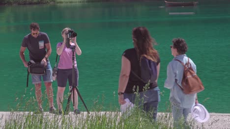 A-professional-couple-setting-up-their-photo-and-or-video-equipment-for-a-shoot-at-lake-Braies,-South-Tyrol,-Italy