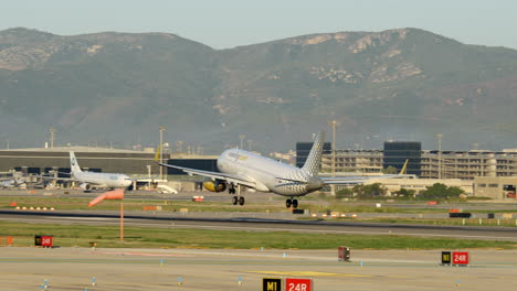 Vueling-Airplane-landing-at-sunrise-in-Barcelona-Airport-at-sunrise,-telephoto