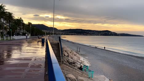 People-Running-At-Promenade-des-Anglais-Along-The-Beach-After-The-Rain-At-Dusk-In-Nice,-France