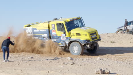 Gelber-Rennwagen,-Der-Während-Der-Dakar-rallye-Mit-Hoher-Geschwindigkeit-In-Der-Heißen-Und-Trockenen-Arabischen-Wüste-Im-Gelände-Fährt