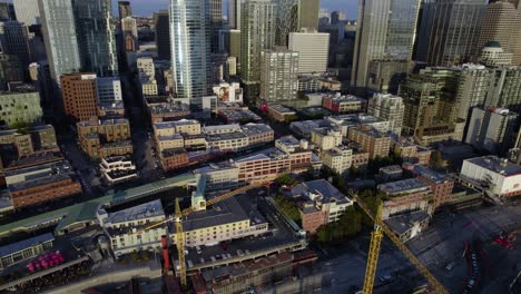 Aerial-view-overlooking-a-road-construction-site-in-downtown-Seattle,,-golden-hour,-in-Washington,-USA---tilt,-drone-shot