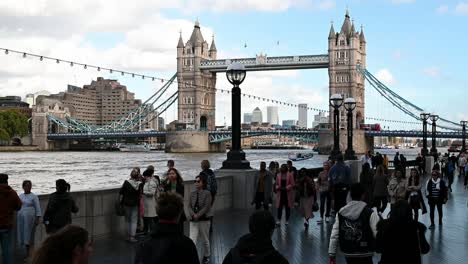 People-walking-towards-Tower-Bridge-along-The-Queens-Walk,-London,-United-Kingdom