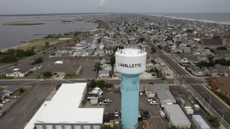 Aerial-view-over-the-water-tower-in-cloudy-Lavallette,-New-Jersey,-USA---tilt,-drone-shot