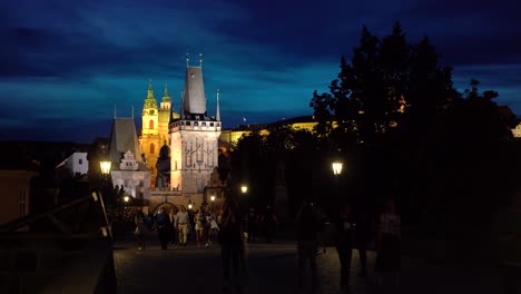 Evening-shot-of-the-Charles-Bridge-in-Prague-with-tourists,-looking-at-Mala-Strana-Bridge-Tower