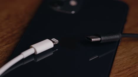 Verschiedene-Ladekabel-Auf-Der-Rückseite-Eines-Apple-Iphone-Handys-Auf-Dem-Schreibtisch-Verlegt