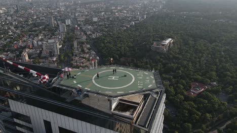 Aerial-panning-timelapse-shot-over-Ritz-Carlton-building-in-Mexico-City-with-people-on-helipad-on-a-sunny-day