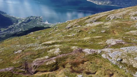 Many-people-hiking-on-queens-hiking-trail-with-beautiful-panoramic-fjord-view-and-Lofthus-village-far-down-below---Summer-aerial-Hardanger-Norway