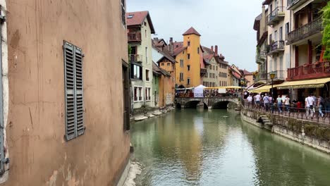 Thiou-Canal-And-The-Morens-Bridge-In-The-Old-Town-In-Annecy,-France---panning-shot