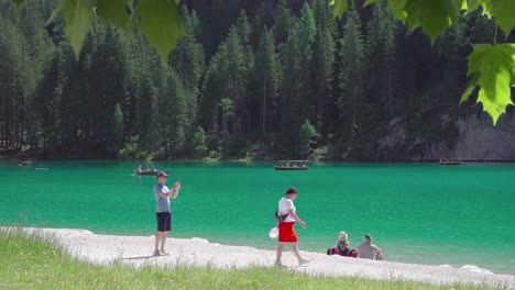 A-young-men-taking-a-picture-on-his-mobile-phone-of-his-companion-at-the-shores-of-lake-Braies