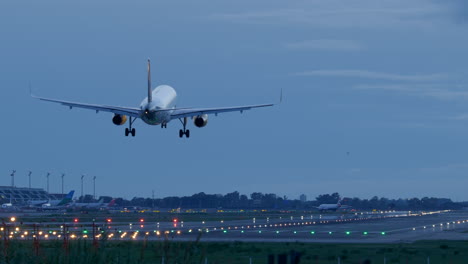 Rear-telephoto-shot-of-Vueling-plane-approaching-landing-area-at-airport,-dusk