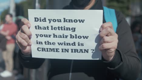 Hombre-Sujetando-Un-Cartel-De-Protesta-Contra-El-Opresivo-Régimen-Iraní-En-Dublín,-Irlanda