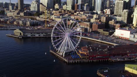 Luftaufnahme,-Die-Das-Seattle-Great-Wheel-Umkreist-Und-Die-Skyline-Der-Stadt-Enthüllt,-Goldene-Stunde-Im-Nordwesten-Der-Usa