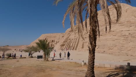 Blick-Auf-Palmen-Außerhalb-Des-Nefertari-Tempels-Mit-Touristen,-Die-Vorbeigehen