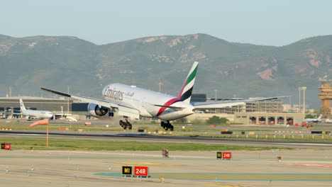 Emirates-commercial-airplane-landing-in-Barcelona-Airport,-tracking-shot,-day