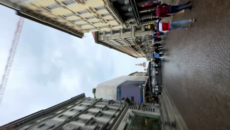 Vertical-shot-of-people-walking-on-high-street-shopping-in-Milan,-Italy