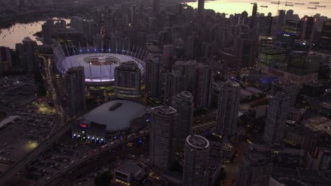 Aerial-view-around-the-BC-Place-Stadium-and-Rogers-place,-dusk-in-Vancouver,-Canada---circling,-drone-shot