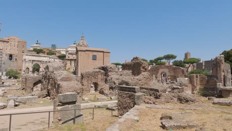 Tourists-are-sightseeing-remains-of-the-Roman-Empire,-surviving-structures-of-Roman-Forum-in-Rome