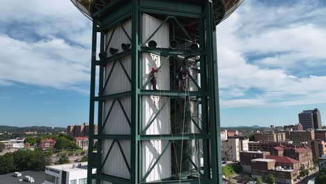 Aerial-view-of-people-working-on-the-Sunsphere-tower-in-Knoxville,-USA---approaching,-drone-shot