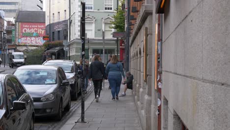 Wow-Burger-Sign-With-Pedestrians-Walking-In-The-Sidewalk-Of-Temple-Bar-Street-In-Dublin,-Ireland