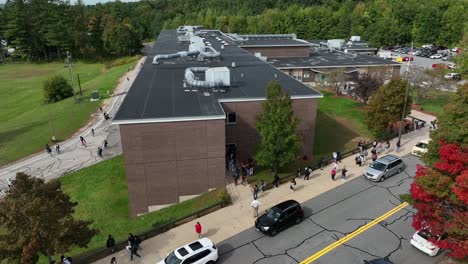 Aerial-footage-of-students-leaving-American-public-school-building-on-a-fall-afternoon-in-the-northeast
