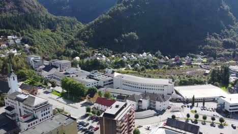 Massive-famous-industrial-buildings-from-Dale-factories-in-Dalekvam-Vaksdal-Norway---Aerial-from-from-town-center-looking-down-at-building-mass-close-to-Dale-river-and-mountains