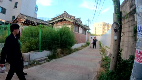 People-walking-through-Bukchon-oriental-village,-Seoul-South-Korea-historical-residential-buildings