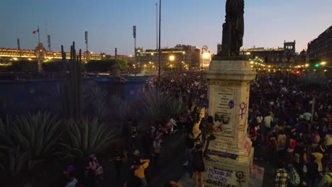 Women-spraying-on-statues-and-rioting-on-the-streets-of-a-city,-protesting-the-rise-of-hate-crimes-against-female-in-Mexico---Aerial-view