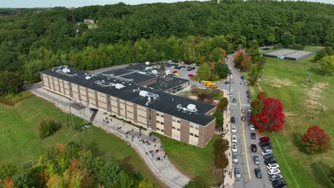 Aerial-rotational-shot-of-large-public-school-during-afternoon-dismissal