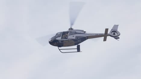 Helicóptero-De-Unidades-Especiales-Militares-Con-Soldado-En-Cabina-Abierta-Volando-En-El-Cielo,-Vista-De-ángulo-Bajo