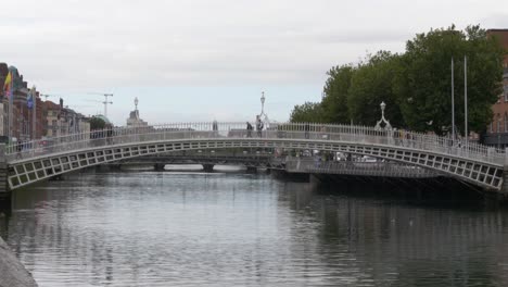 Ha'penny-Pedestrian-Bridge-With-People-Crossing-In-The-City-Center-Of-Dublin,-Ireland