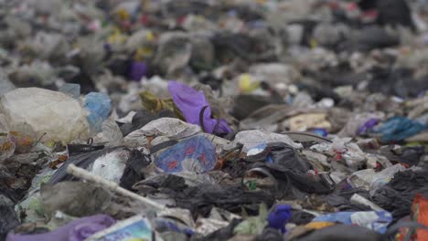 Non-recyclable-waste-dumped-in-a-landfill.-Close-up,-handheld