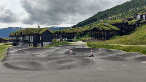 Happy-kids-bicycling-in-pump-track-outside-Myrkdalen-hotel-in-Voss-Norway