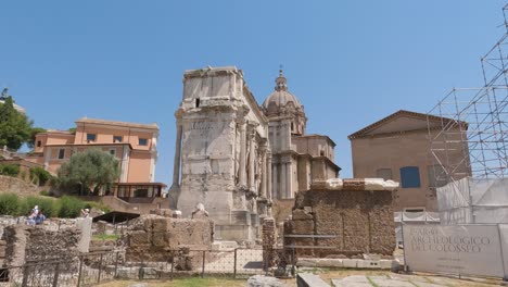 Visitantes-Caminando-En-El-Arco-Septimius-Severus,-El-Foro-Romano,-El-Foro-Romanum,-Rodeado-De-Ruinas-De-Edificios-Antiguos,-Roma