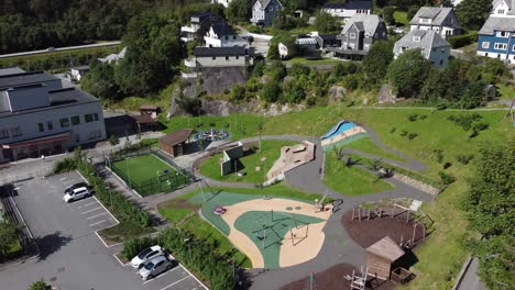 Big-outdoor-playground-connected-to-Dale-school-in-Dalekvam-Vaksdal-Norway---Kids-playing-and-having-fun-on-colorful-playing-field---summer-aerial