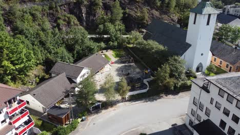 Dale-daycare-in-Dalekvam-aksdal-Norway---Aerial-from-approaching-building-with-playground-and-kids-during-sunny-day